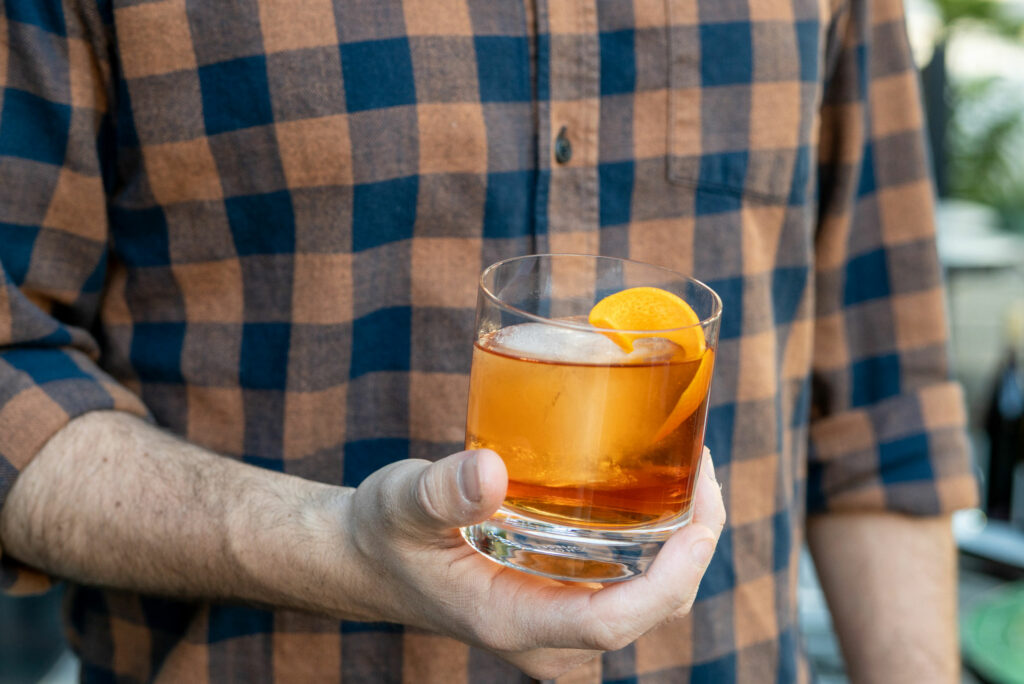 Hand holding a Barrel-Aged Negroni